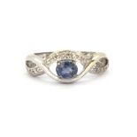 A 9ct white gold ring set with oval cut tanzanite and diamonds, (L.5).