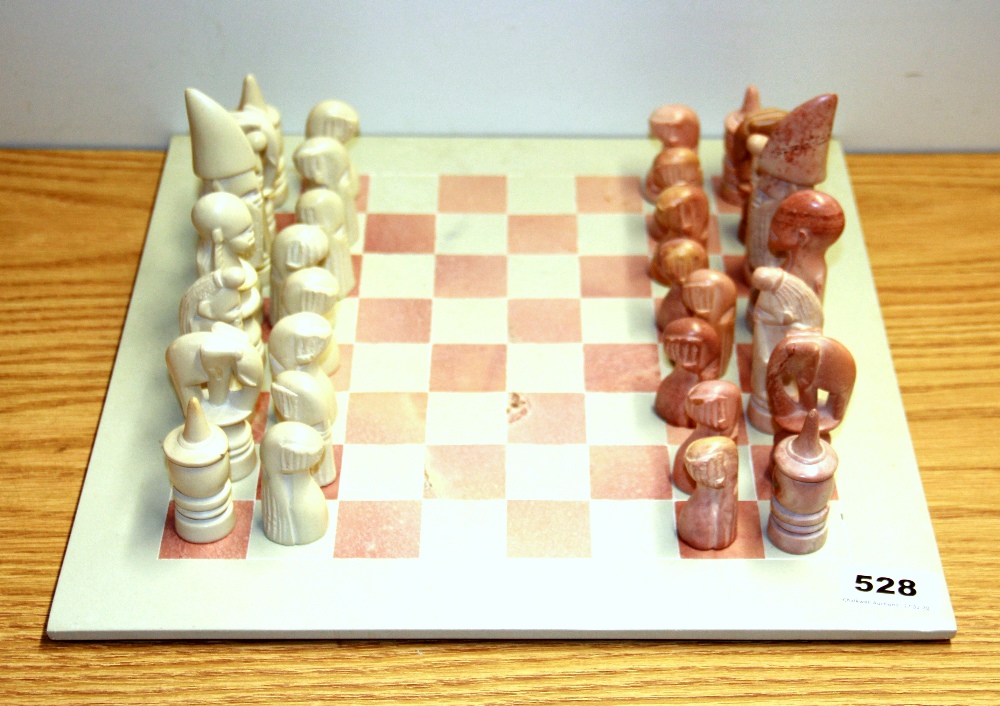 A carved stone chess set, king H. 13cm.