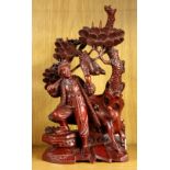 A Chinese carved wooden sculpture depicting a huntsman and his dog, H. 32cm.