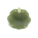 A Chinese carved jadeite jade lock amulet, W. 5cm.