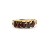 A 9ct yellow gold ring set with five cabochon cut garnets, (P).