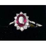 An 18ct white gold ruby and diamond set cluster ring, (O).