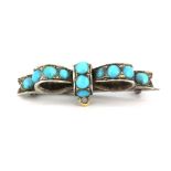 A white metal bow shaped brooch set with turquoise, L. 2.5cm.