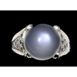 A 925 silver moonstone set ring with sapphire set shoulders, (O.5).