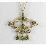 An Edwardian 9ct yellow gold peridot and seed pearl set pendant on a later 9ct gold chain, L. 4.