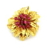 A Toliro Italian 18ct yellow gold (stamped 18k) brooch set with rubies, Dia. 3.5cm.