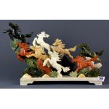 A Chinese carved stone model of eight leaping horses, H. 30cm, L. 50cm.