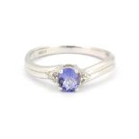 A 9ct white gold ring set with oval cut tanzanite and diamond set shoulders, (L.5).