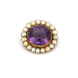 A Victorian yellow metal (tested minimum 9ct gold) brooch set with an oval cut amethyst surrounded