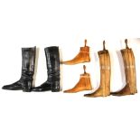 A pair of vintage leather boots with wooden boot trees and pair of wooden shoe trees.