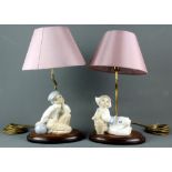 A pair of Lladro table lamps of a Dutch boy and girl with shades, H. 44cm.