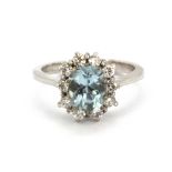 An 18ct white gold cluster ring set with an oval cut blue topaz surrounded by brilliant cut