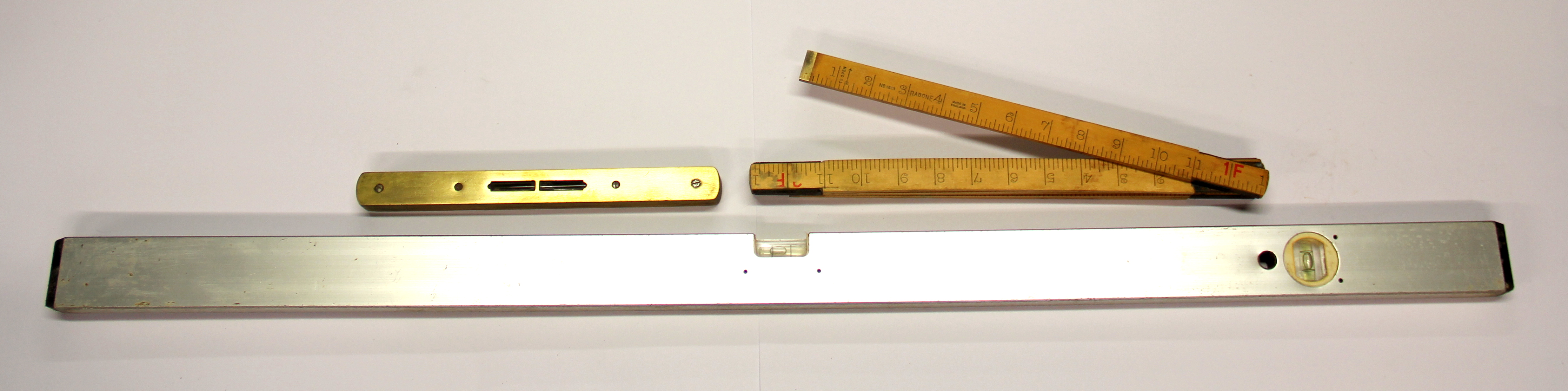 Two spirit levels and a folding wooden ruler.