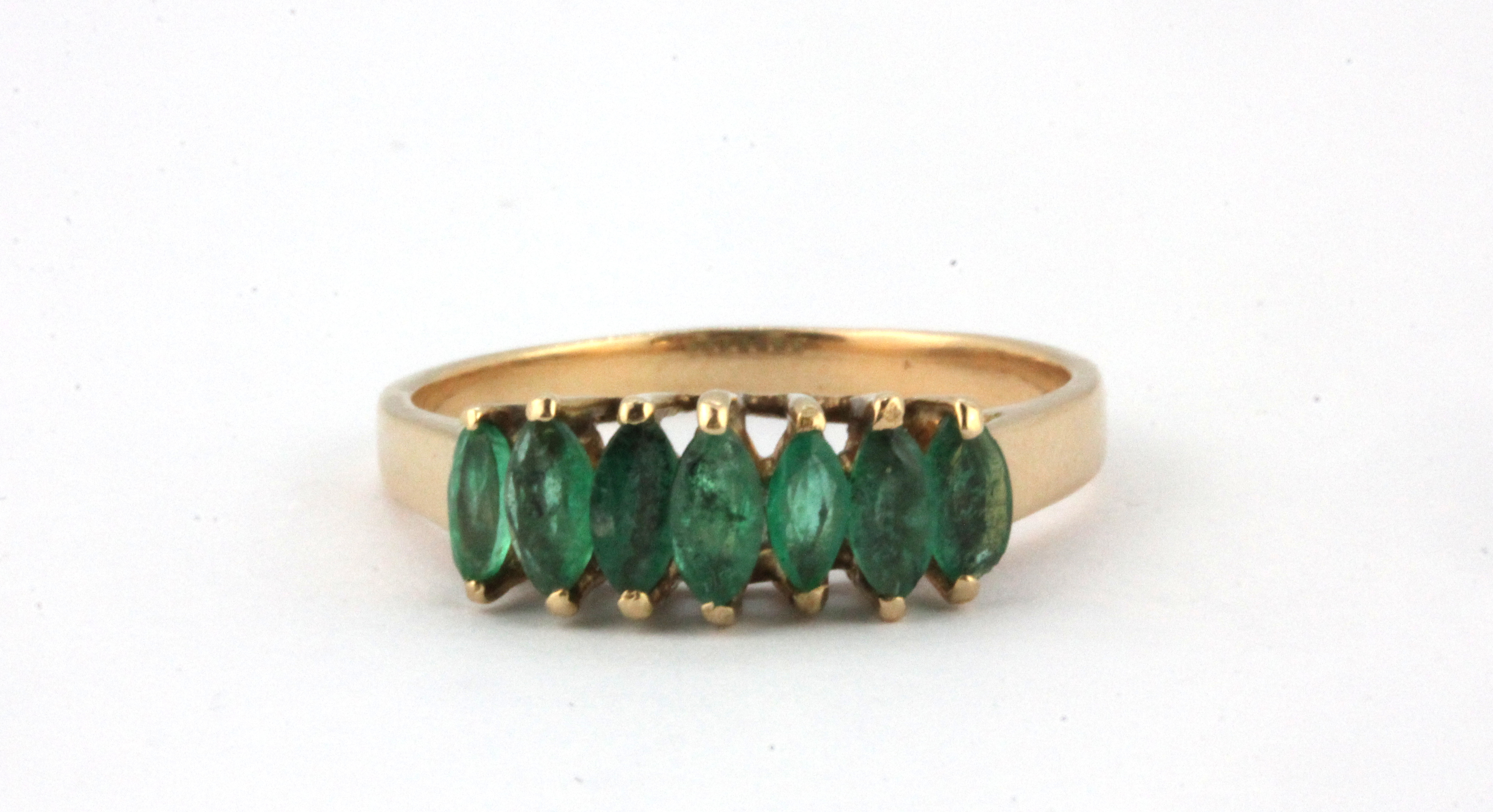 A yellow metal (tested minimum 9ct gold) ring set with marquise cut emeralds, (R).