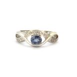 A 9ct white gold ring set with oval cut tanzanite and diamonds, (L.5).