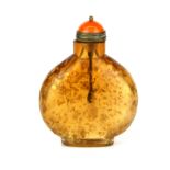 A unusual Chinese amber glass snuff bottle featuring suspended gold leaf with a bronze and