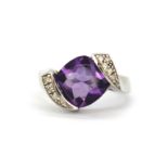 A 9ct white gold ring set with a large cabochon cut amethyst with brilliant cut diamond set