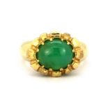 A heavy yellow metal (tested 18ct gold) ring set with a cabochon cut chrysoprase and emeralds, (R).
