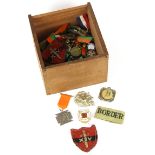 A box of mixed badges and other items.