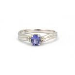 A 9ct white gold ring set with oval cut tanzanite and diamond set shoulders, (L.5).