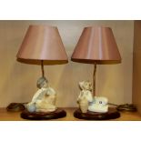 A pair of Lladro table lamps of a Dutch boy and girl with shades, H. 44cm.