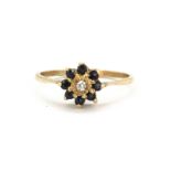 A 9ct yellow gold sapphire and white stone set cluster ring, (T).