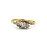 An 18ct yellow gold and platinum three diamond set crossover ring, (Q).