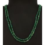 A two row emerald bead necklace on a white metal clasp set with rose cut diamonds and a pearl, L.