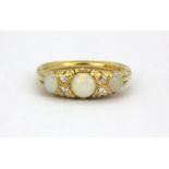 An 18ct yellow gold ring set with three cabochon cut opals and diamonds, (N).