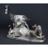 A large Lladro figure of a boy with goats and a dog, H. 34cm, W. 42cm (A/F to one goat horn).