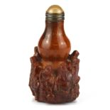 A Chinese carved antler snuff bottle decorated with immortals and with bronze and hardstone stopper,