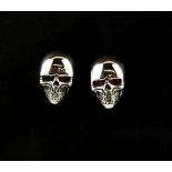 A pair of 925 silver skull earrings set with rubies, H. 1.3cm.