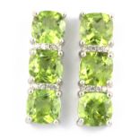 A pair of 925 silver earrings set with three cushion cut peridots and white stones, L. 2cm.