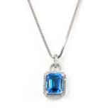 An 18ct white gold (stamped 750) pendant set with an emerald cut blue topaz surrounded by