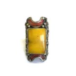 A Tibetan white metal man's ring set with faux amber and faux coral, top L. 4cm.