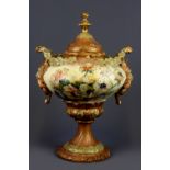 A 19th Century hand painted Continental porcelain urn and lid with green man handles, H. 30cm.
