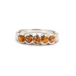 A 9ct white gold ring set with five round cut citrines, (H).