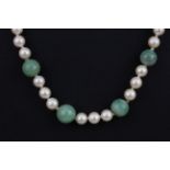 A polished jade bead and faux pearl necklace on a 9ct yellow gold clasp, L. 46cm.