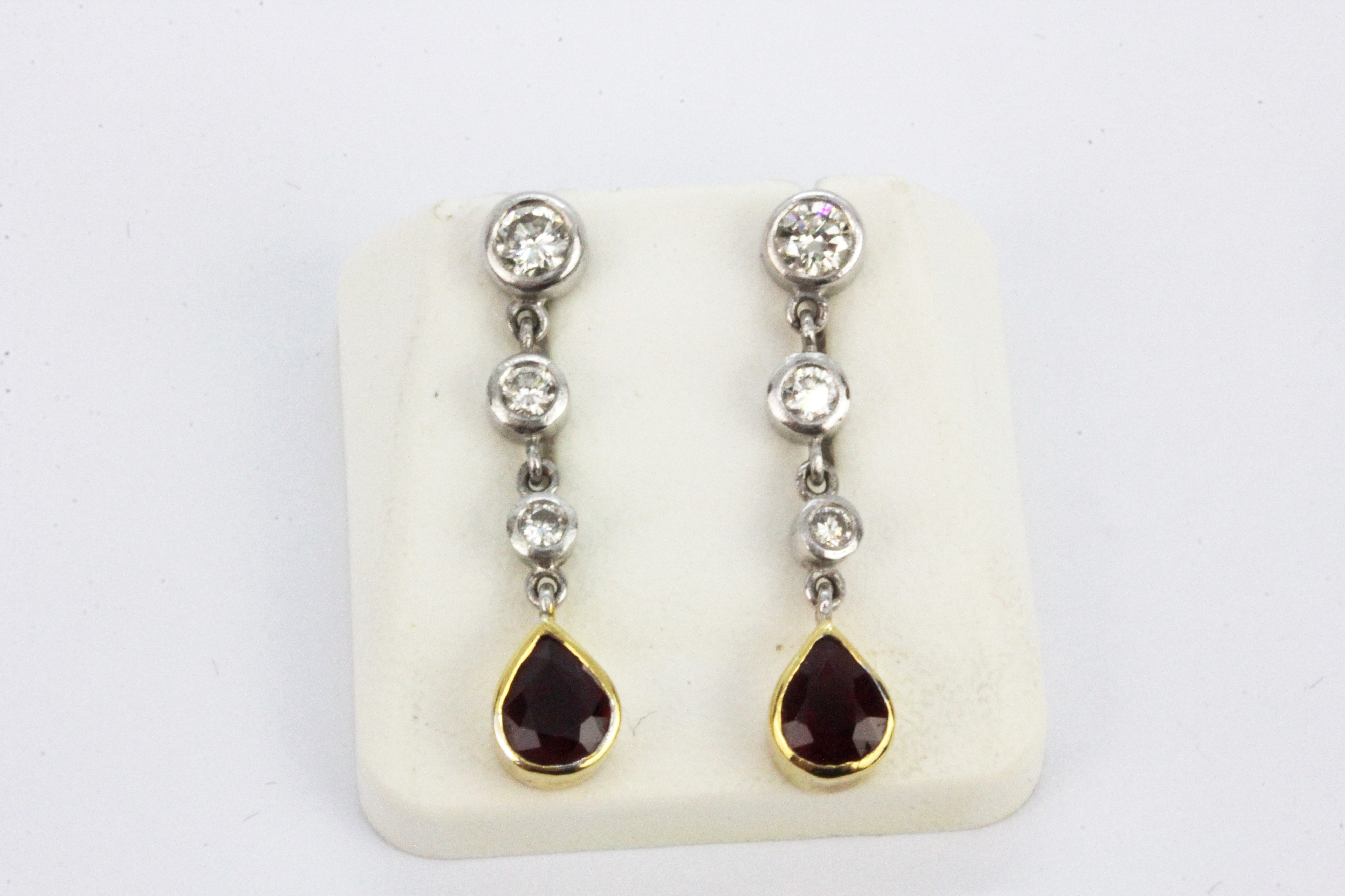 A pair of 18ct white gold drop earrings set with pear cut rubies and brilliant cut diamonds, L. 2.