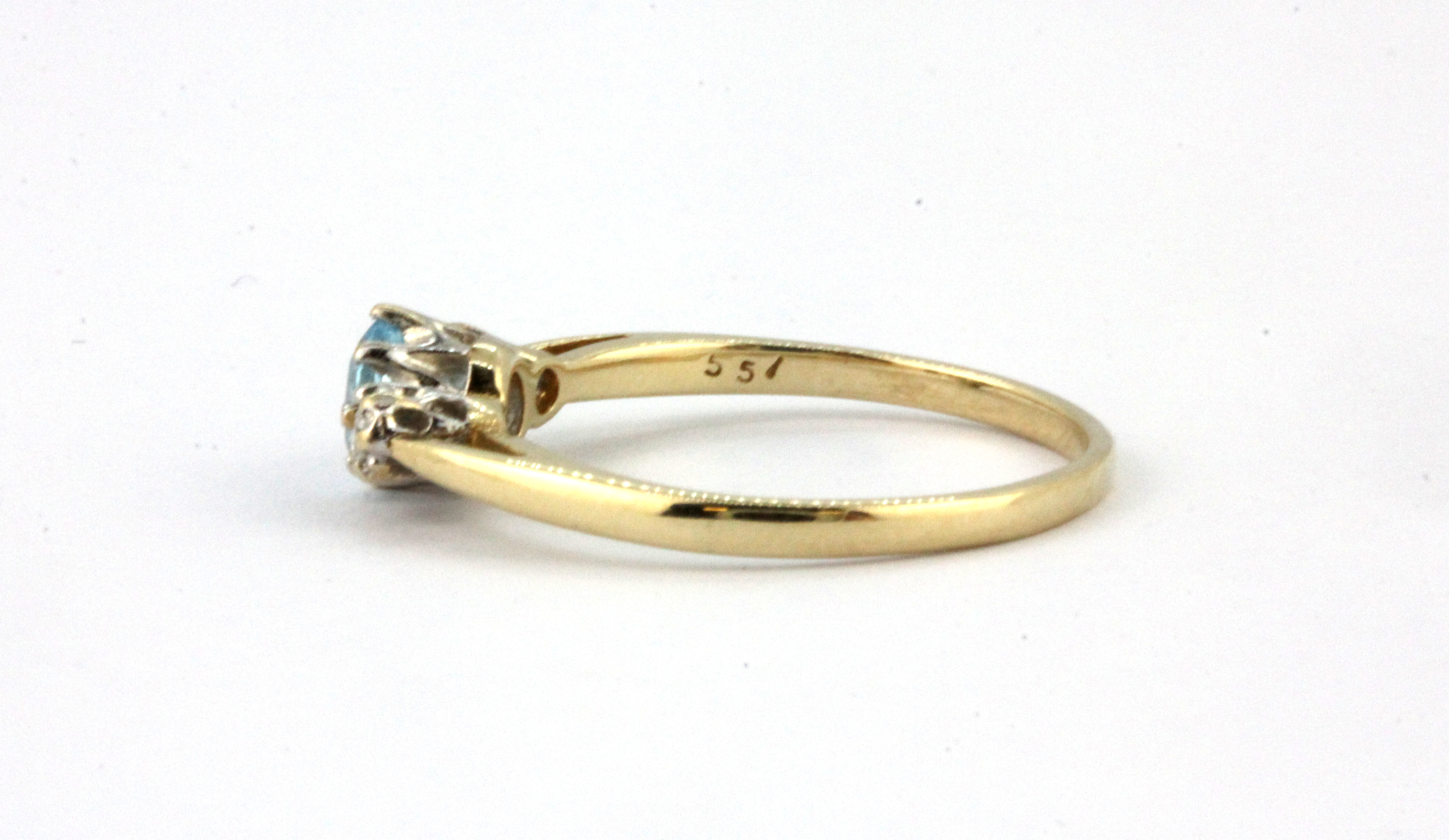 A 9ct yellow gold ring set with an oval cut aquamarine and diamond set shoulders, (O). - Image 2 of 2