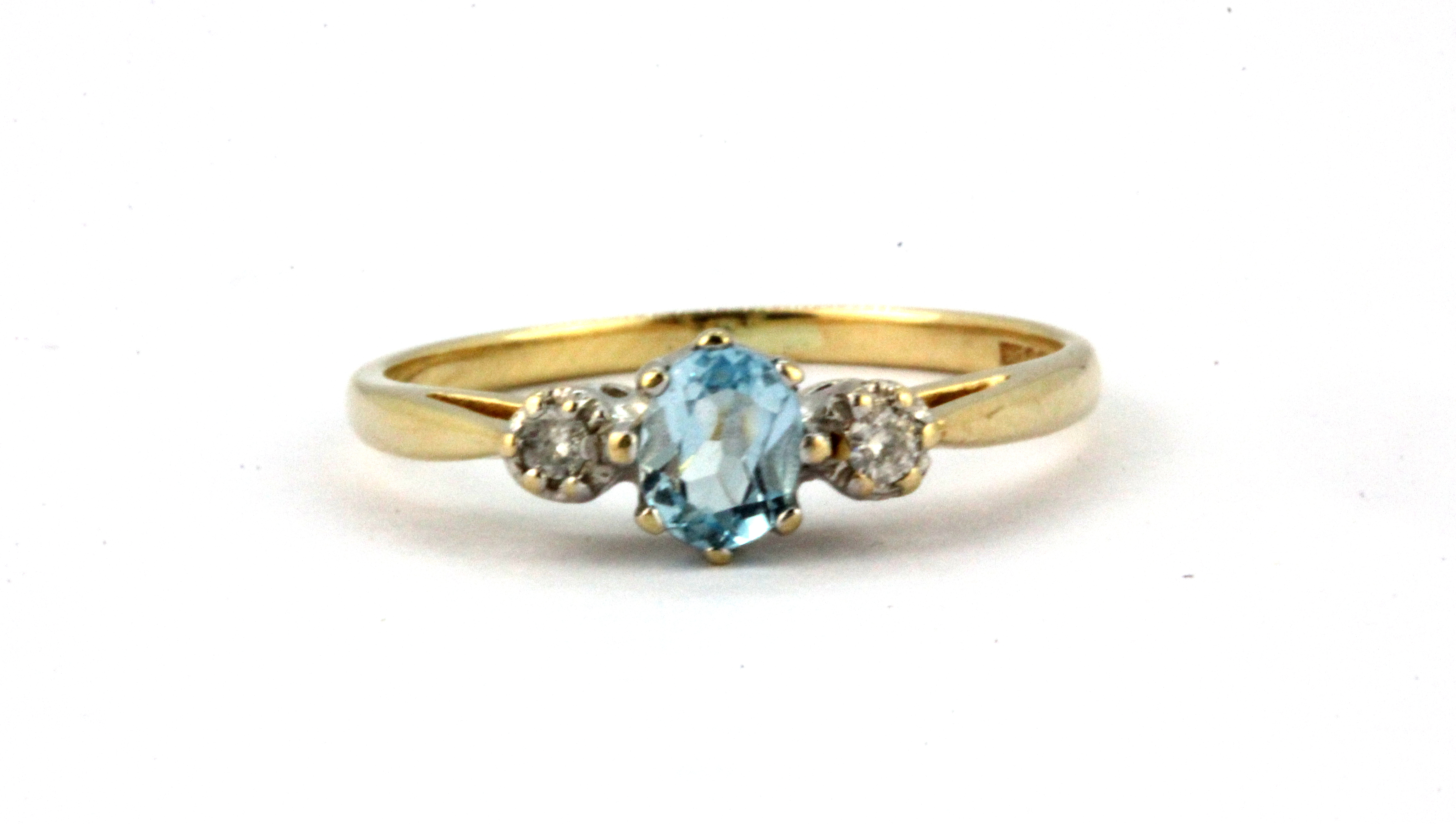 A 9ct yellow gold ring set with an oval cut aquamarine and diamond set shoulders, (O).