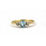 A 9ct yellow gold ring set with an oval cut aquamarine and diamond set shoulders, (O).