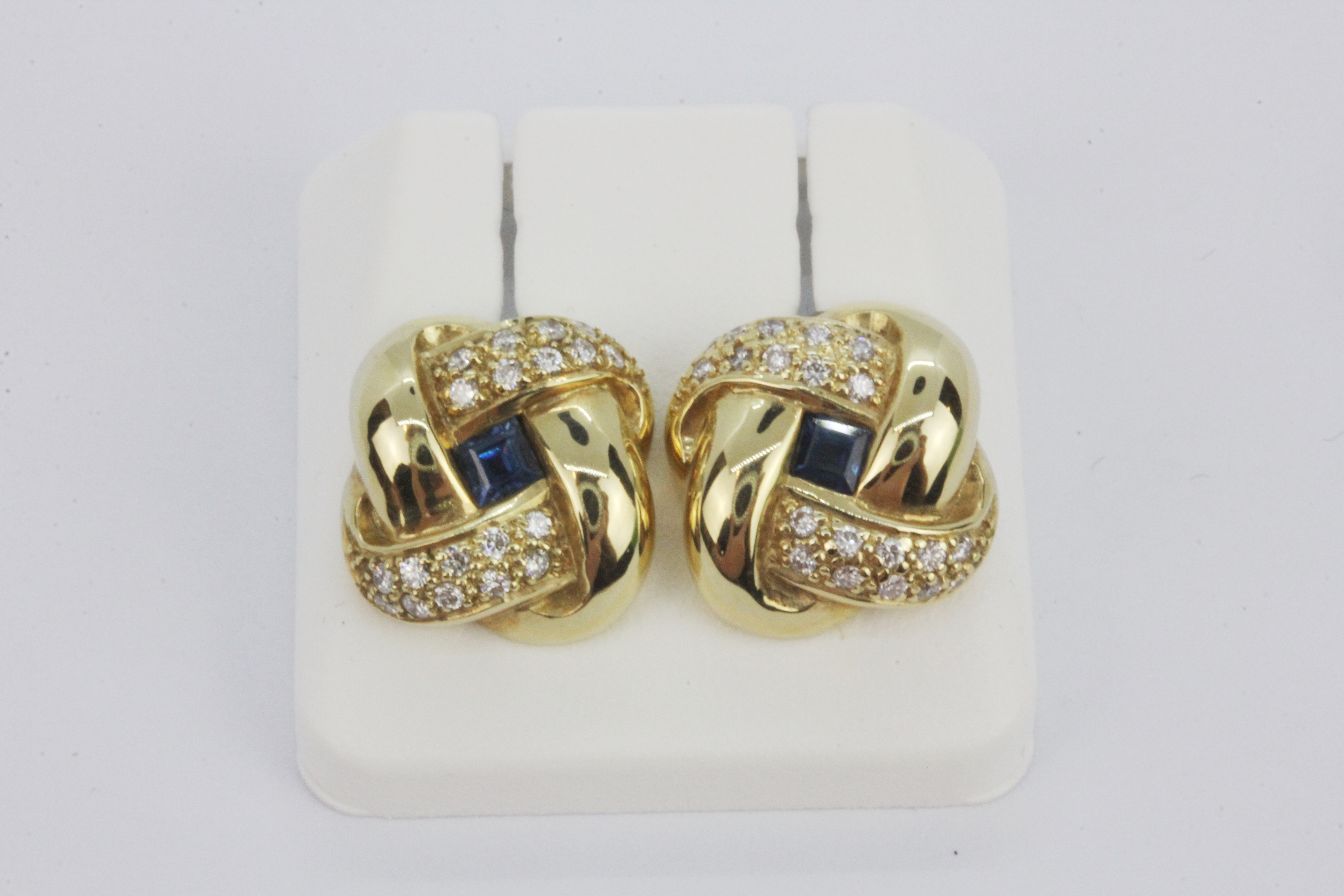 A pair of 18ct white gold stud earrings set with step cut sapphires and diamonds, L. 1.5cm.