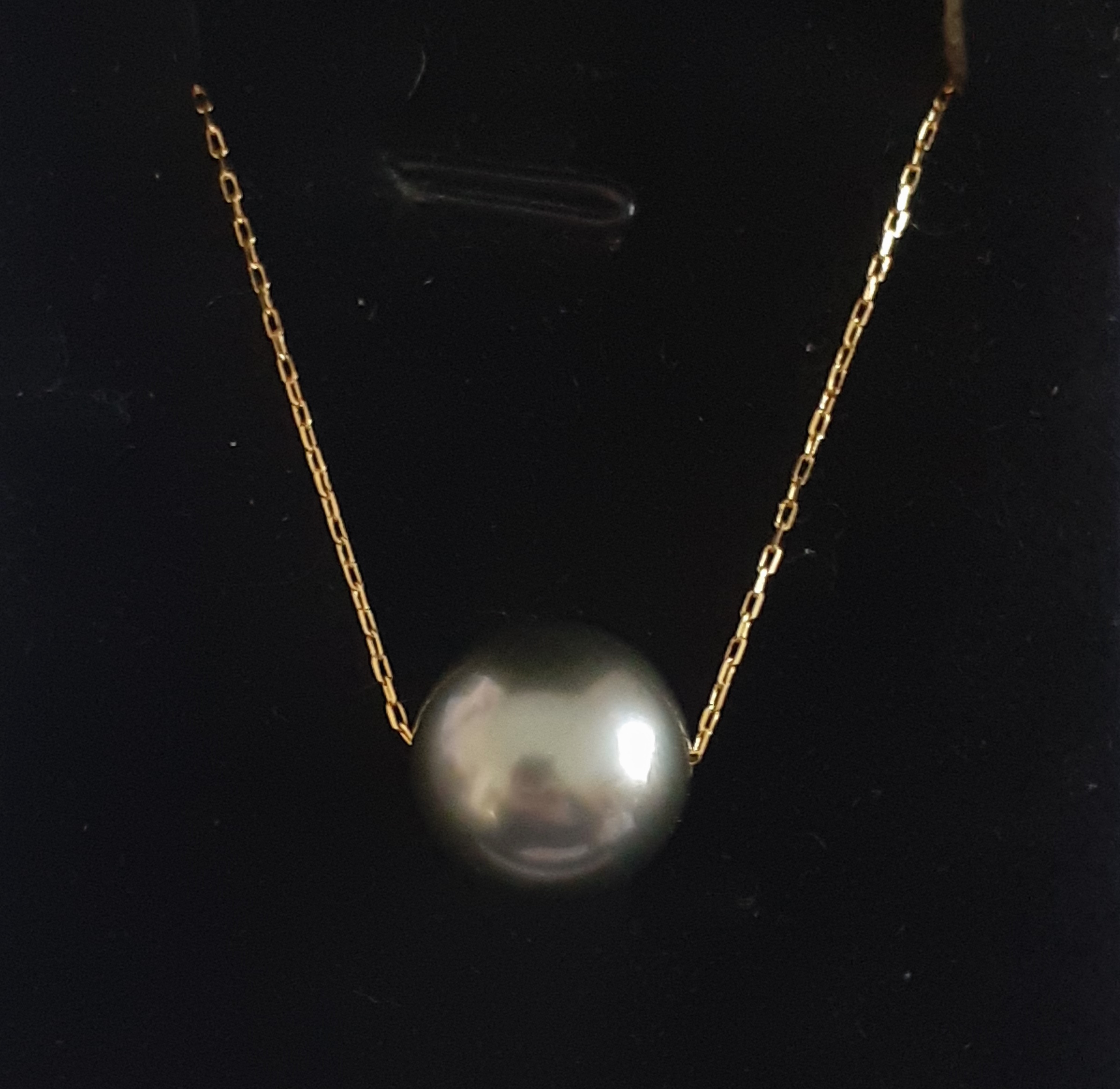 An 18ct yellow gold (stamped 750) necklace set with a grey South Sea pearl, Dia. 1.2cm, L. 42cm.