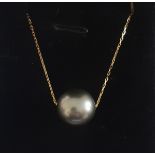 An 18ct yellow gold (stamped 750) necklace set with a grey South Sea pearl, Dia. 1.2cm, L. 42cm.