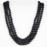 A triple row black pearl necklace, L. 43cm, pearl dia. 6mm.