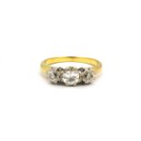 A yellow metal (tested 18ct gold) ring set with three old cut diamonds, (M).