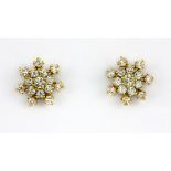 A pair of yellow metal (tested 18ct gold) diamond set snowflake shaped earrings, on 14ct gold