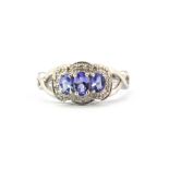 A 9ct white gold triple cluster ring set with three graduated oval cut tanzanites and diamonds, (