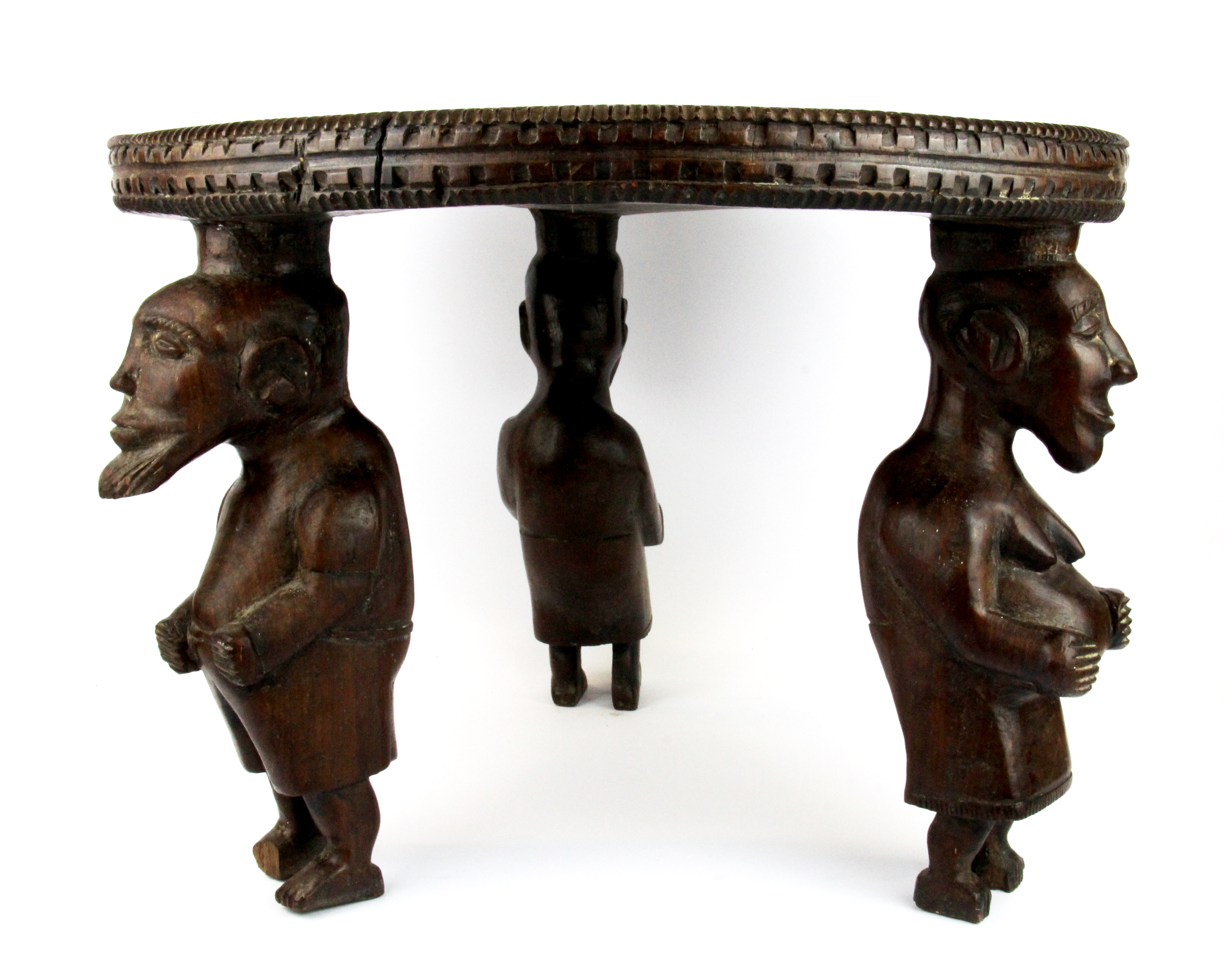 A rare African carved tribal hardwood table/stool with figural legs carved from a single piece of